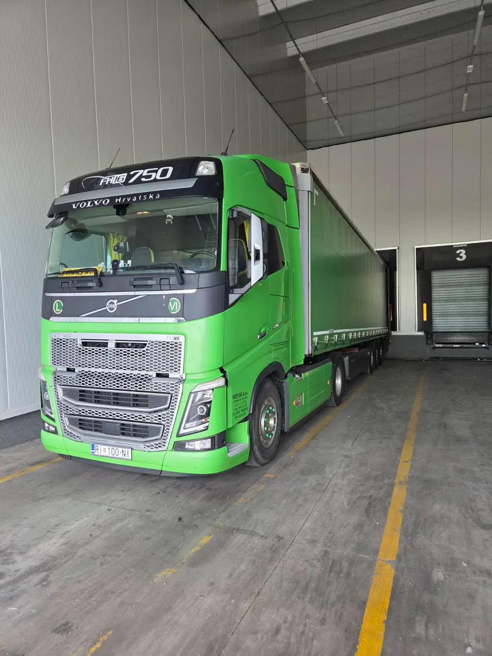 Zeleni NISMAR Volvo FH16 s poluprikolicom na utovaru